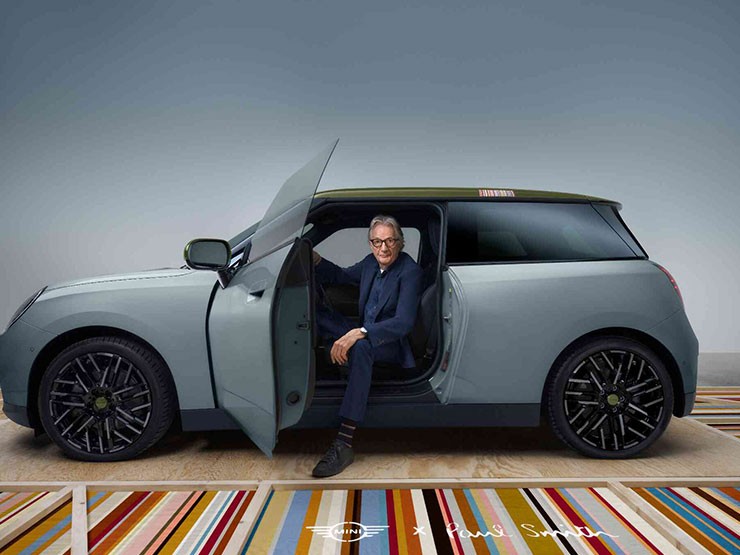 Front side view of the all-electric MINI Cooper Paul Smith Edition in Inspired White with designer Paul Smith